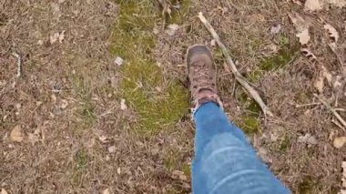 Kyiv, Ukrayna 6 Mart 2024: Yürüyüş ayakkabılarıyla ormanda yürümek, birinci şahıs manzarası. Kadının bacakları yakın çekim, adımlar. İlkbaharda orman, güzel havada.