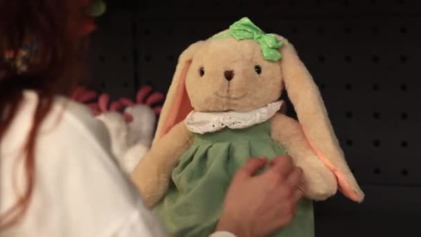 キエフ ウクライナ 2024年3月26日 ソフトオモチャ 女性の手は プッシュウサギ クローズアップを持っています おもちゃを店舗で販売しています 豪華なイースターバニーを選択する買い物客のクローズアップ — ストック動画