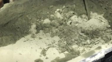 Beton sıva, havan topu. Çekiç matkabıyla çimento harcı karıştırmak, konakta inşaat. Bir inşaatçı çimento alçısını hazırlar, yakın plan. İnşaat alanında çimento harcı.