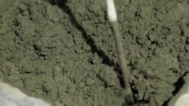 Beton sıva, havan topu. Çekiç matkabıyla çimento harcı karıştırmak, konakta inşaat. Bir inşaatçı çimento alçısını hazırlar, yakın plan. İnşaat alanında çimento harcı.