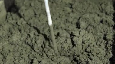 Beton sıva, havan topu. Çekiç matkabıyla çimento harcı karıştırmak, konakta inşaat. Bir inşaatçı çimento alçısını hazırlar, yakın plan. İnşaat alanında çimento harcı.