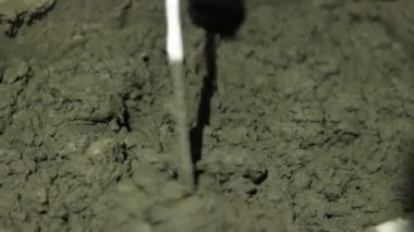 Beton sıva, havan topu. Çekiç matkabıyla çimento harcı karıştırmak, konakta inşaat. Bir inşaatçı çimento alçısını hazırlar, yakın plan. İnşaat alanında çimento harcı.