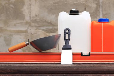 İnşaat ya da sıva kepçesi, bir spatula, bir inşaat seviyesi ve astar için bir kap. Kır evi tadilatı, inşaat. Bir inşaatçı için kompozisyon ve eşyalar gerekli. Sıva araçları