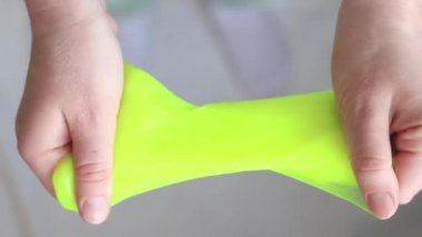Kız sarı mukusu yoğuruyor. Kadının elleri parlak sarı balçığı yakından gerer. Rahatlamak için stres önleyici bir oyuncak. Kafanı işten ya da okuldan uzaklaştıracak bir şey. Eğlenceli bir duyusal aktivite