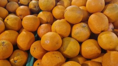 Süpermarkette portakal satışı. Plastik kutularda citrus meyveleri, seçici odaklı yakın çekim. Portakallar mağazanın yan görünümünde. Olgun, sulu, parlak portakal meyvesi. C vitamini ile zenginleştirilmiş meyve.