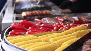 Fuarın yemek bölümünde elektrikli ızgara. Büyük döner ızgara ve çeşit çeşit et ve sebzelerle. Döner ızgara. Et, mantar, biber ve domates pişirmek. Sokak yemeği.