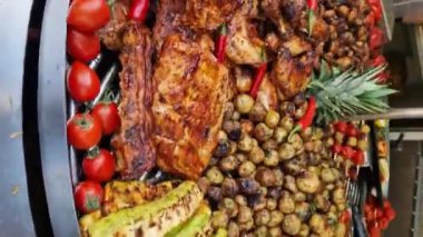 Fuarın yemek bölümünde elektrikli ızgara. Büyük döner ızgara ve çeşit çeşit et ve sebzelerle. Döner ızgara. Et, mantar, biber ve domates pişirmek. Sokak yemeği.