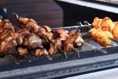 Şişe kebapları, yakın plan. Panayırda yemek, açık hava yemekleri. Sıcak ve lezzetli yemekler. Kömürde şiş kebap pişiriyorum. Metal bir şişte pişirilmiş ızgara kebap.
