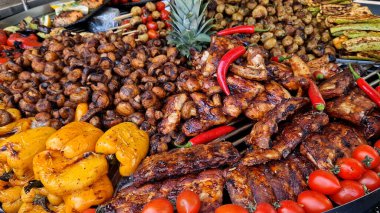 Büyük döner ızgara ve çeşit çeşit et ve sebzelerle. Döner ızgara. Pişmiş et, patates, mantar, kabak, biber ve domates gösterisi. Sokak yemeği. Yemek katı. Adil