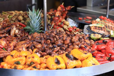 Büyük döner ızgara ve çeşit çeşit et ve sebzelerle. Döner ızgara. Pişmiş et, patates, mantar, kabak, biber ve domates gösterisi. Sokak yemeği. Yemek katı. Adil