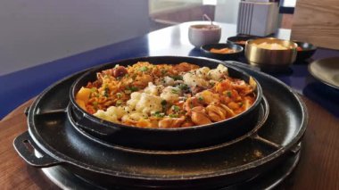 Takkalp. Kızarmış tavuk, tokpokki, lahana, erişte ve mozzarella ile ızgara tava. Kore yemeği. Peynirli Koreli Baharatlı Tavuk. Lokantadaki sıcak ve lezzetli yemekler. Asya yemekleri
