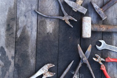 Tahta bir yüzey üzerinde eski iş aletleri, üst manzara. Çekiç, balyoz, metal makas, kerpeten ve daha fazlası. El aleti. İnşaat Günü ya da Babalar Günü. İnşaat ve yenileme konsepti