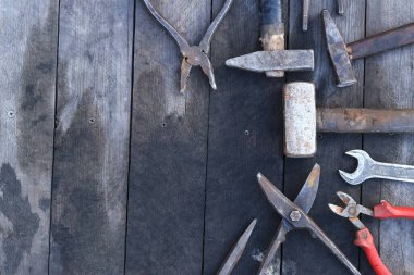 Tahta bir yüzey üzerinde eski iş aletleri, üst manzara. Çekiç, balyoz, metal makas, kerpeten ve daha fazlası. El aleti. İnşaat Günü ya da Babalar Günü. İnşaat ve yenileme konsepti