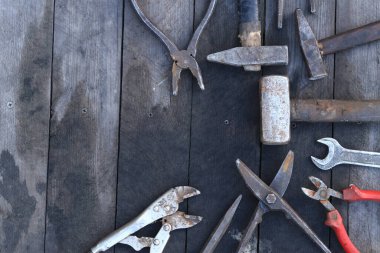 Tahta bir yüzey üzerinde eski iş aletleri, üst manzara. Çekiç, balyoz, metal makas, kerpeten ve daha fazlası. El aleti. İnşaat Günü ya da Babalar Günü. İnşaat ve yenileme konsepti