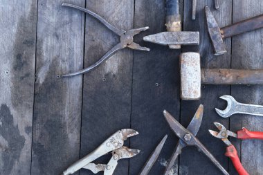 Tahta bir yüzey üzerinde eski iş aletleri, üst manzara. Çekiç, balyoz, metal makas, kerpeten ve daha fazlası. El aleti. İnşaat Günü ya da Babalar Günü. İnşaat ve yenileme konsepti