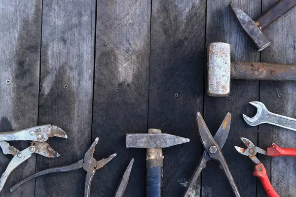 Tahta bir yüzey üzerinde eski iş aletleri, üst manzara. Çekiç, balyoz, metal makas, kerpeten ve daha fazlası. El aleti. İnşaat Günü ya da Babalar Günü. İnşaat ve yenileme konsepti
