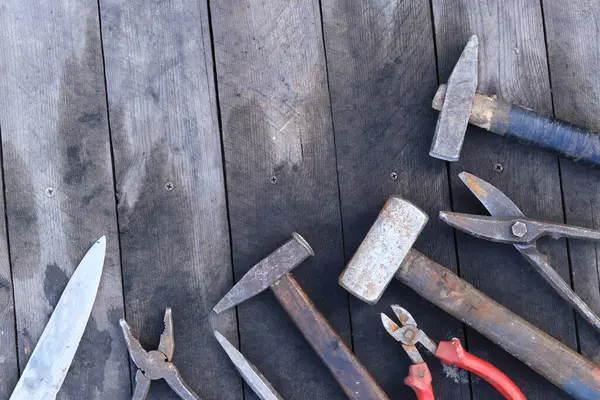 Tahta bir yüzey üzerinde eski iş aletleri, üst manzara. Çekiç, balyoz, teneke makas, kerpeten ve bıçak. El aleti. İnşaat Günü ya da Babalar Günü. İnşaat ve yenileme konsepti