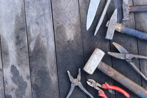 Tahta bir yüzey üzerinde eski iş aletleri, üst manzara. Çekiç, balyoz, teneke makas, kerpeten ve bıçak. El aleti. İnşaat Günü ya da Babalar Günü. İnşaat ve yenileme konsepti