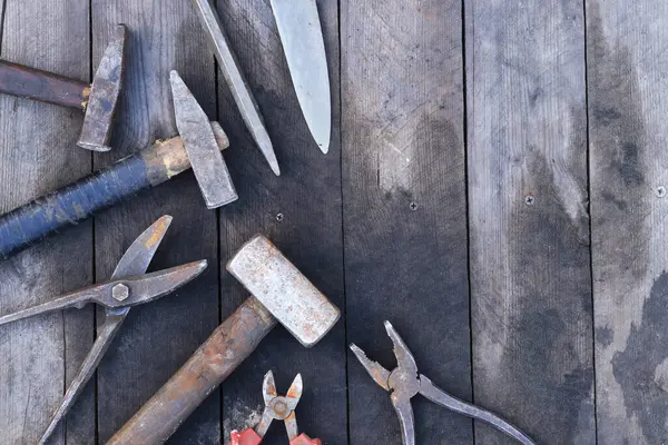 Tahta bir yüzey üzerinde eski iş aletleri, üst manzara. Çekiç, balyoz, teneke makas, kerpeten ve bıçak. El aleti. İnşaat Günü ya da Babalar Günü. İnşaat ve yenileme konsepti