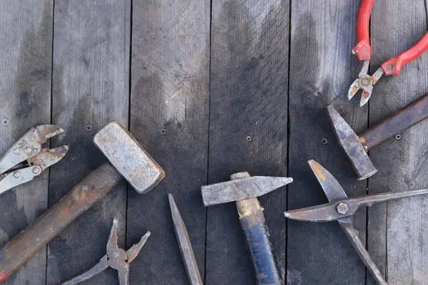 Tahta bir yüzey üzerinde eski iş aletleri, üst manzara. Çekiç, balyoz, metal makas, kerpeten ve daha fazlası. El aleti. İnşaat Günü ya da Babalar Günü. İnşaat ve yenileme konsepti