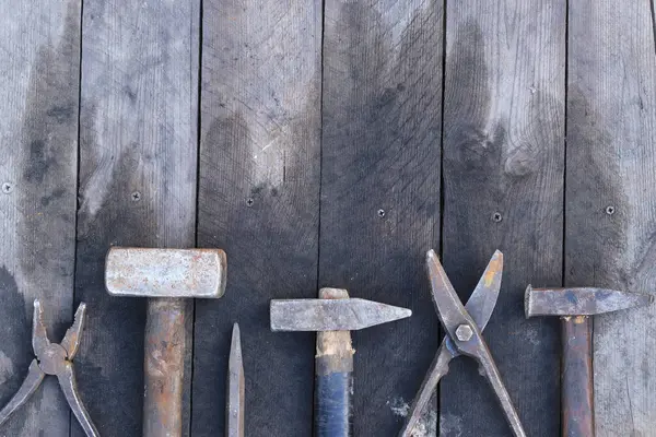 Tahta bir yüzey üzerinde eski iş aletleri, üst manzara. Çekiç, balyoz, metal makas, kerpeten ve daha fazlası. El aleti. İnşaat Günü ya da Babalar Günü. İnşaat ve yenileme konsepti