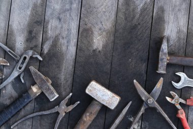 Tahta bir yüzey üzerinde eski iş aletleri, üst manzara. Çekiç, balyoz, metal makas, kerpeten ve daha fazlası. El aleti. İnşaat Günü ya da Babalar Günü. İnşaat ve yenileme konsepti