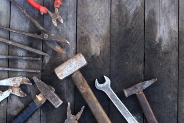 Tahta bir yüzey üzerinde eski iş aletleri, üst manzara. Çekiç, balyoz, metal makas, kerpeten ve daha fazlası. El aleti. İnşaat Günü ya da Babalar Günü. İnşaat ve yenileme konsepti