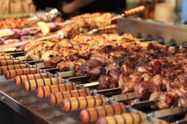Şişe kebapları, yakın plan. Panayırda yemek, açık hava yemekleri. Sıcak ve lezzetli yemekler. Kömürde şiş kebap pişiriyorum. Metal bir şişte pişirilmiş ızgara kebap.