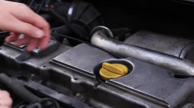 Yağ değişimi. Bir kadının eli yağ dolgu kapağını açar ya da kapatır. Dizel bir arabanın motorunun yağını değiştirmek. Araba bakımı. Eski araba.