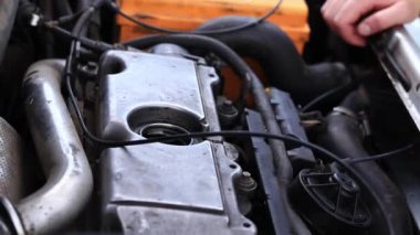 Yağ değişimi. Bir kadının eli yağ dolgu kapağını açar ya da kapatır. Dizel bir arabanın motorunun yağını değiştirmek. Araba bakımı. Eski araba.