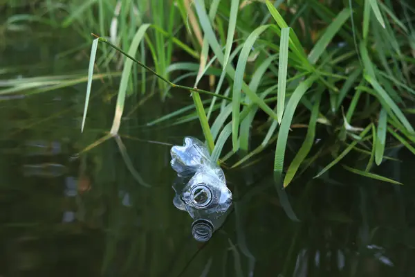 stock image Plastic bottle in water, lake or river. Plastic pollution. Pollution of reservoirs and rivers. Garbage in the river close-up. An abandoned bottle floats on the lake. Food plastic in river water