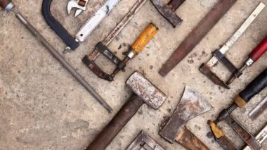 Beton arka planda eski inşaat aletleri, üst manzara. Çekiç, inşaat kıskacı, düz dosya, balyoz, el testeresi ve pense. Antika el aletleri koleksiyonu
