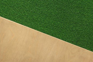 Ahşap arka planda yeşil yapay çimen halısı. Yapay çimenler, üst manzara. Arkaplan