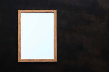 Fotoğraf için boş çerçeve ya da siyah ahşap zemin üzerinde beyaz çarşaf ile metin. Basit ahşap çerçeve. Mesaj için yer. Kopyalama alanı olan boş fotoğraf