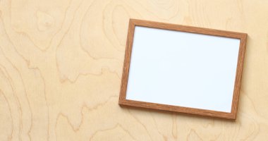 Fotoğraf için boş çerçeve ya da açık tahta zemin üzerinde beyaz çarşaf olan metin. Basit ahşap çerçeve. Mesaj için yer. Kopyalama alanı olan boş fotoğraf