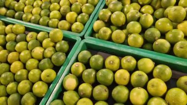 Markette meyve, plastik kutularda limon satışı. Limon satışı, seçici odaklanma. Süpermarketteki ürünler. Plastik kutularda turunçgil meyveleri, yakın plan. Olgun, sulu, yeşil meyveli C vitamini.