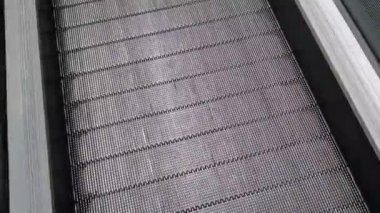 Alışveriş merkezinde düz yürüyen merdiven. Halka açık bir yerde yürüyen merdivene binmek. Şehir hayatı kavramı, acele. Yürüyen yürüyen merdiven, üst görünüm