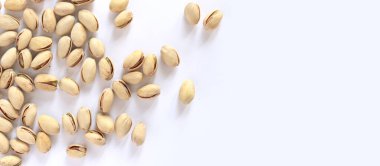 Beyaz arka planda fıstıklar. Hafif arkaplanlı, seçici odaklı bir avuç kuru fıstıklı fıstık. Kabuklu şam fıstığı. Yakın plan.