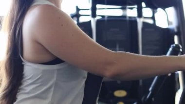 Lat pull, sırt kası eğitim makinesi. Spor kulübünde spor yapan bir kız. Makinede yoğun bir eğitim var, yakın plan. Spor yaşam tarzı. Güç makinesiyle kadın eğitimi