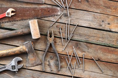 Tamir için eski el aletleri seti, üst manzara. Tahta zeminde el aletleri. Ahşap bir yüzeyde eski el aletleri. Balyoz, balta, testere, kerpeten, ayarlanabilir anahtar, dosya ve çivi. Tamir için herşey