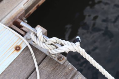 Demirleme kalesi, bir yat iskelesinde bağlama düğümü. Yatın bağlama ipleri diz kapağına bağlı. Halatları bağlamak için iskelede diz çökün. Bağlama ve bağlama ipleri için diz çökün