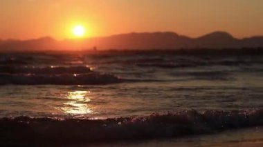 Denizde gün batımı. Balear Denizi, Salou, İspanya. Kumsal, deniz, küçük dalgalar. Sahilde akşam manzarası. Denizde tatil.