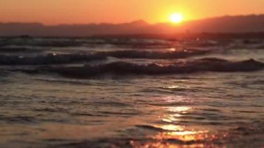 Denizde gün batımı. Balear Denizi, Salou, İspanya. Kumsal, deniz, küçük dalgalar. Sahilde akşam manzarası. Denizde tatil.