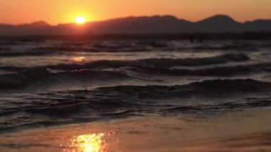 Denizde gün batımı. Balear Denizi, Salou, İspanya. Kumsal, deniz, küçük dalgalar. Sahilde akşam manzarası. Denizde tatil.