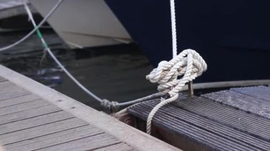 Demirleme kalesi, bir yat iskelesinde bağlama düğümü. Yatın bağlama ipleri diz kapağına bağlı. Halatları bağlamak için iskelede diz çökün. Bağlama ve bağlama ipleri için diz çökün