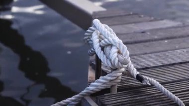 Demirleme kalesi, bir yat iskelesinde bağlama düğümü. Yatın bağlama ipleri diz kapağına bağlı. Halatları bağlamak için iskelede diz çökün. Bağlama ve bağlama ipleri için diz çökün
