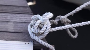 Demirleme kalesi, bir yat iskelesinde bağlama düğümü. Yatın bağlama ipleri diz kapağına bağlı. Halatları bağlamak için iskelede diz çökün. Bağlama ve bağlama ipleri için diz çökün