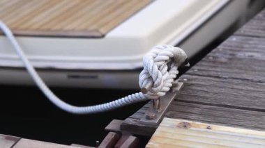 Demirleme kalesi, bir yat iskelesinde bağlama düğümü. Yatın bağlama ipleri diz kapağına bağlı. Halatları bağlamak için iskelede diz çökün. Bağlama ve bağlama ipleri için diz çökün