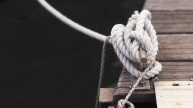 Demirleme kalesi, bir yat iskelesinde bağlama düğümü. Yatın bağlama ipleri diz kapağına bağlı. Halatları bağlamak için iskelede diz çökün. Bağlama ve bağlama ipleri için diz çökün