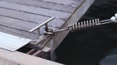 Demirleme kalesi, bir yat iskelesinde bağlama düğümü. Yatın bağlama ipleri diz kapağına bağlı. Halatları bağlamak için iskelede diz çökün. Bağlama ve bağlama ipleri için diz çökün